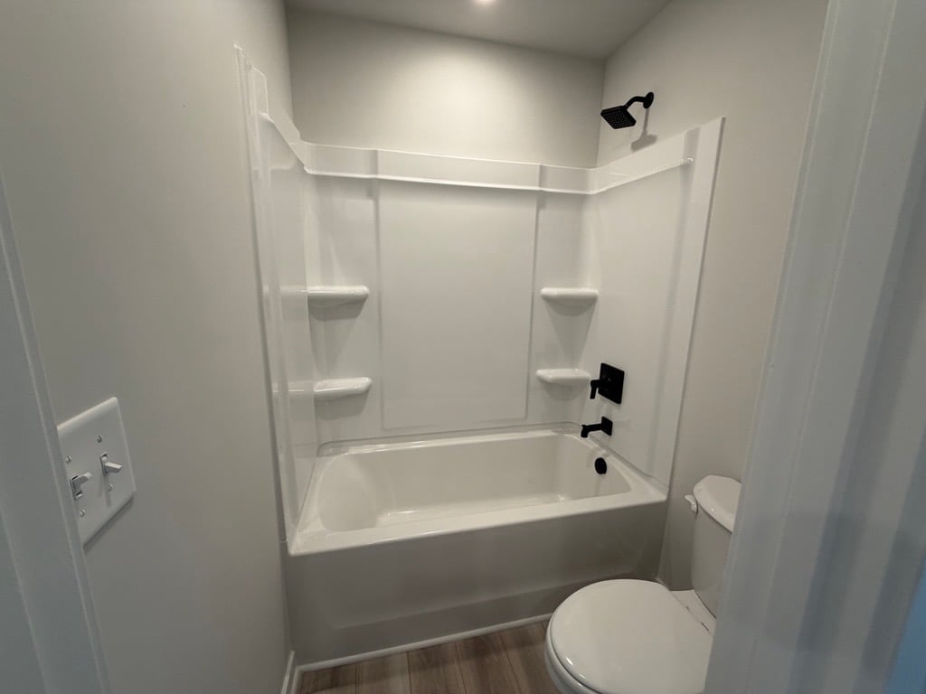 A bathroom with a bathtub and toilet.