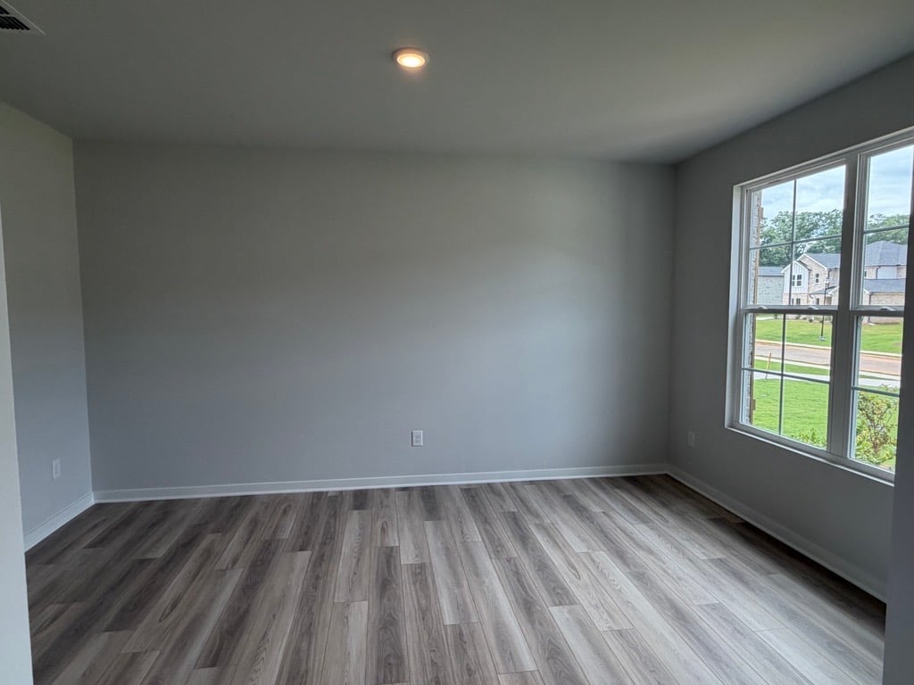 A room with a wood floor and windows.
