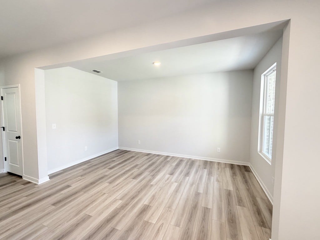 A room with a wood floor and white walls.