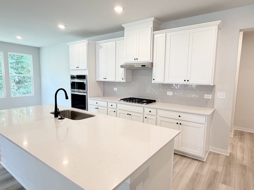 A kitchen with white cabinets.