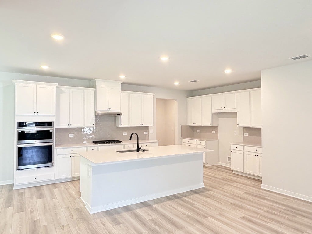 A kitchen with white cabinets.