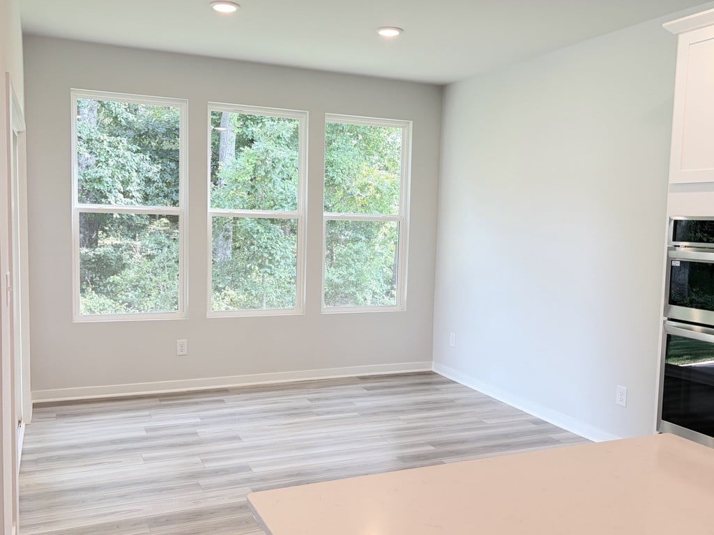 A room with a wood floor and windows.