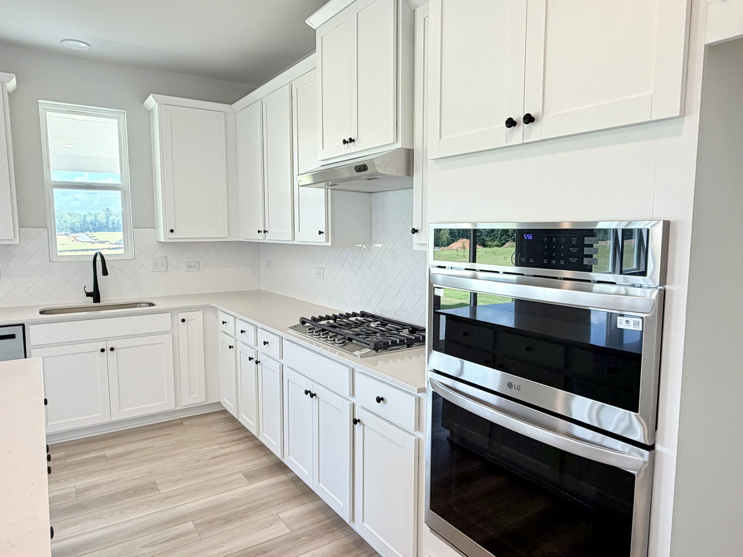 A kitchen with white cabinets.