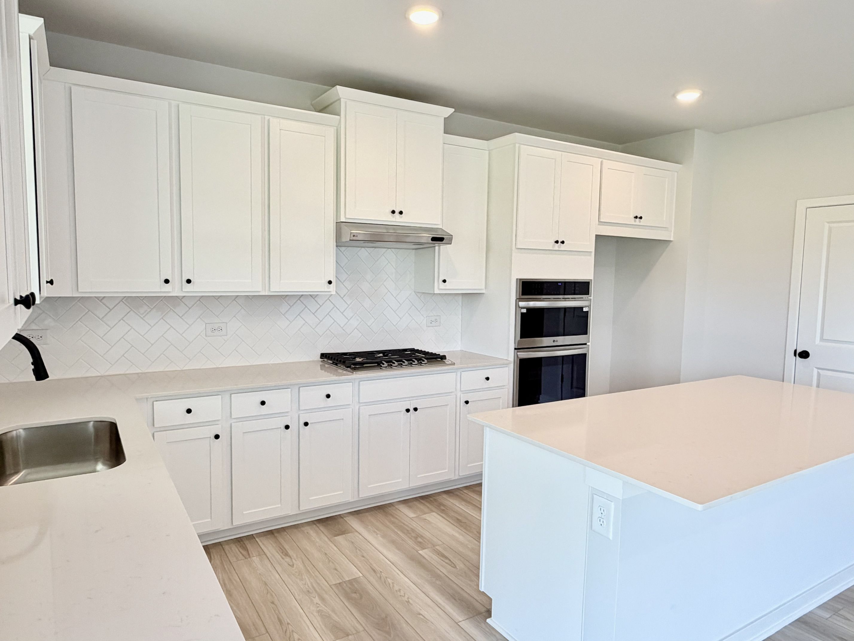 A kitchen with white cabinets.
