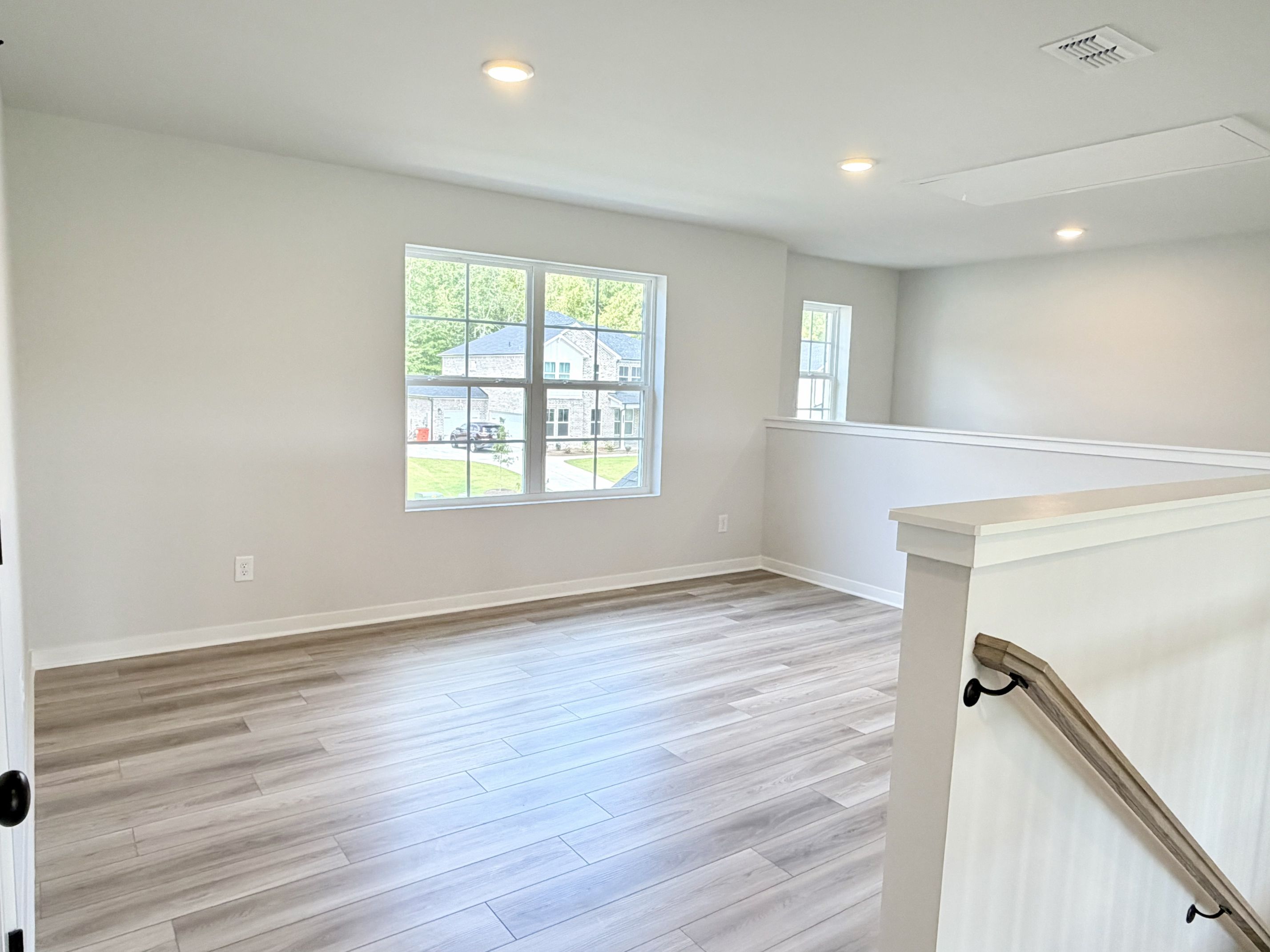 A room with a wood floor and a wood floor with a window.