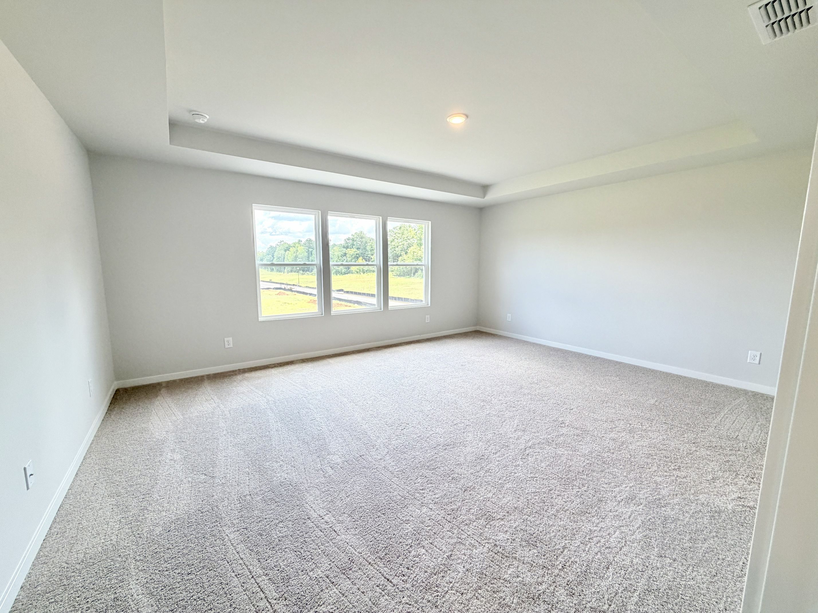 A room with a carpet and windows.