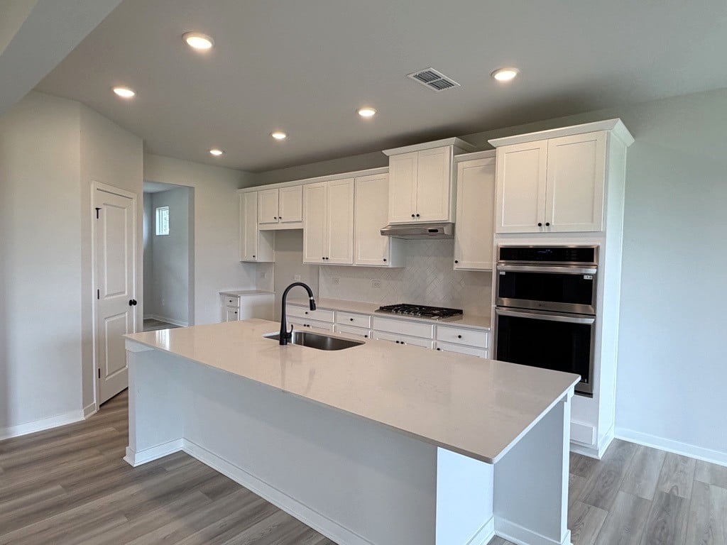 A kitchen with white cabinets.