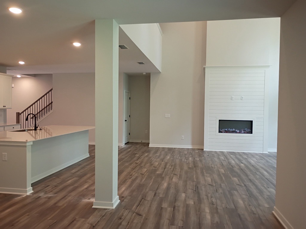 A room with a wood floor and white cabinets.