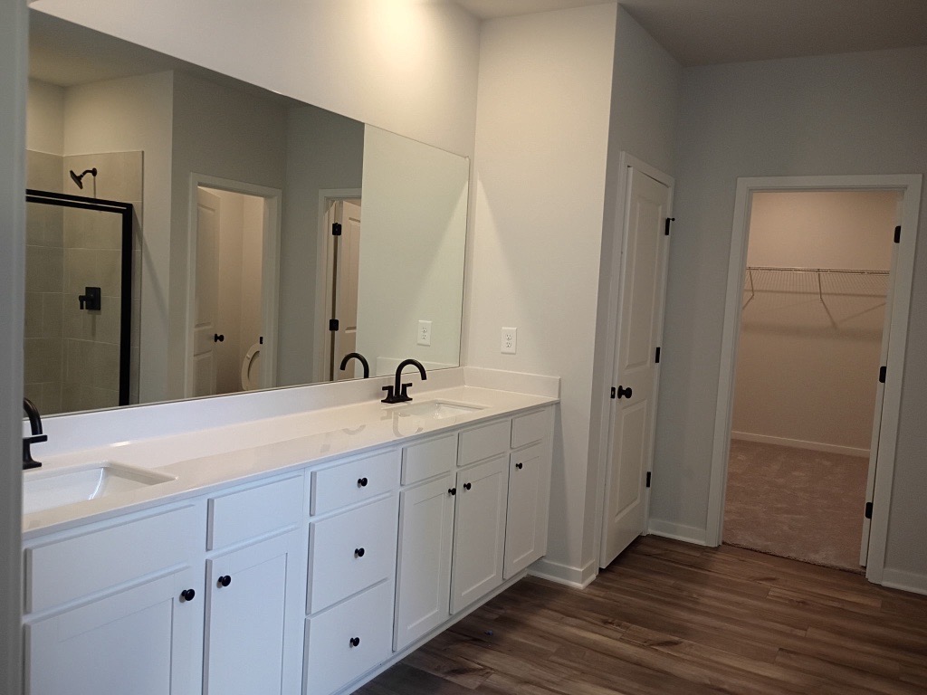 A bathroom with white cabinets.
