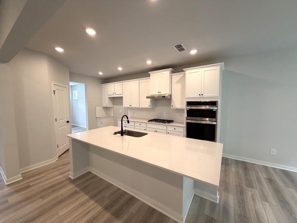 A kitchen with white cabinets.