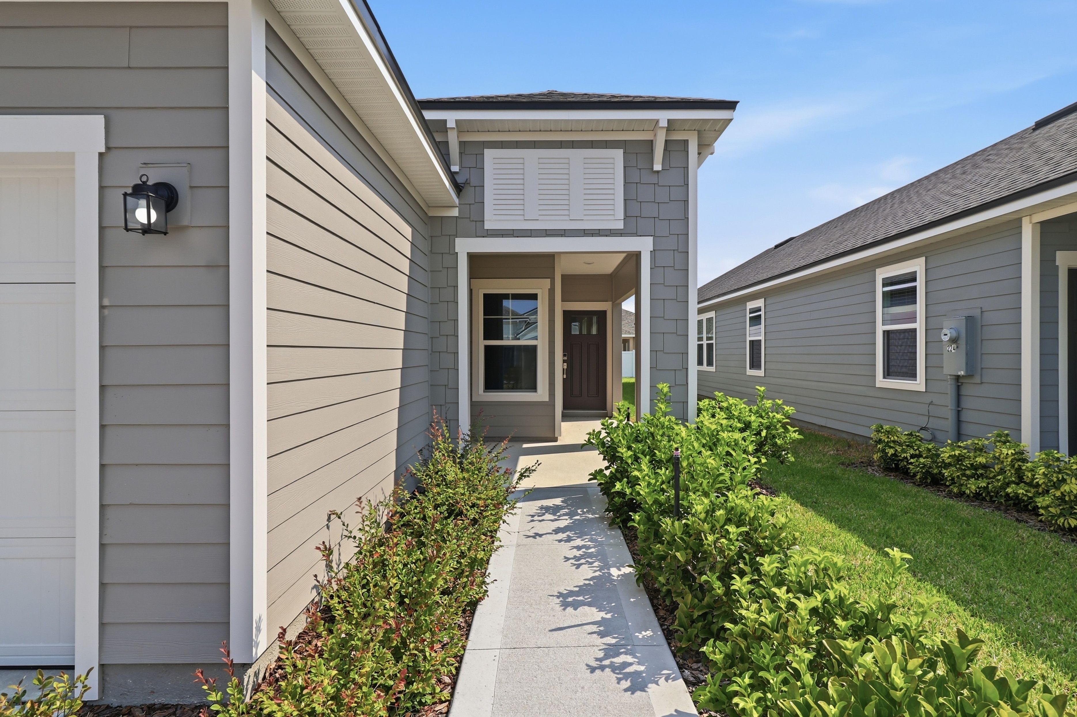 A house with a walkway and grass.