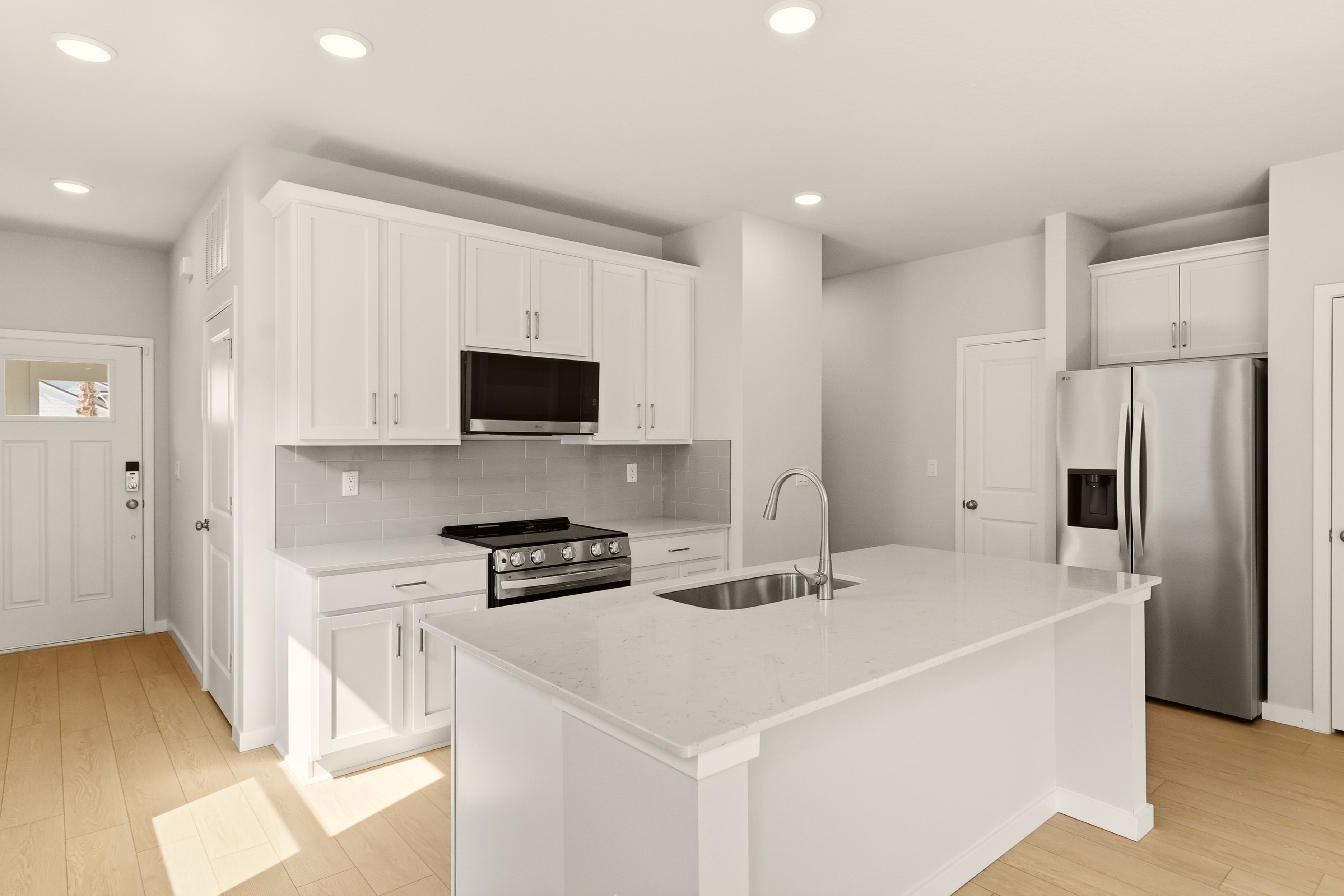 A kitchen with white cabinets.