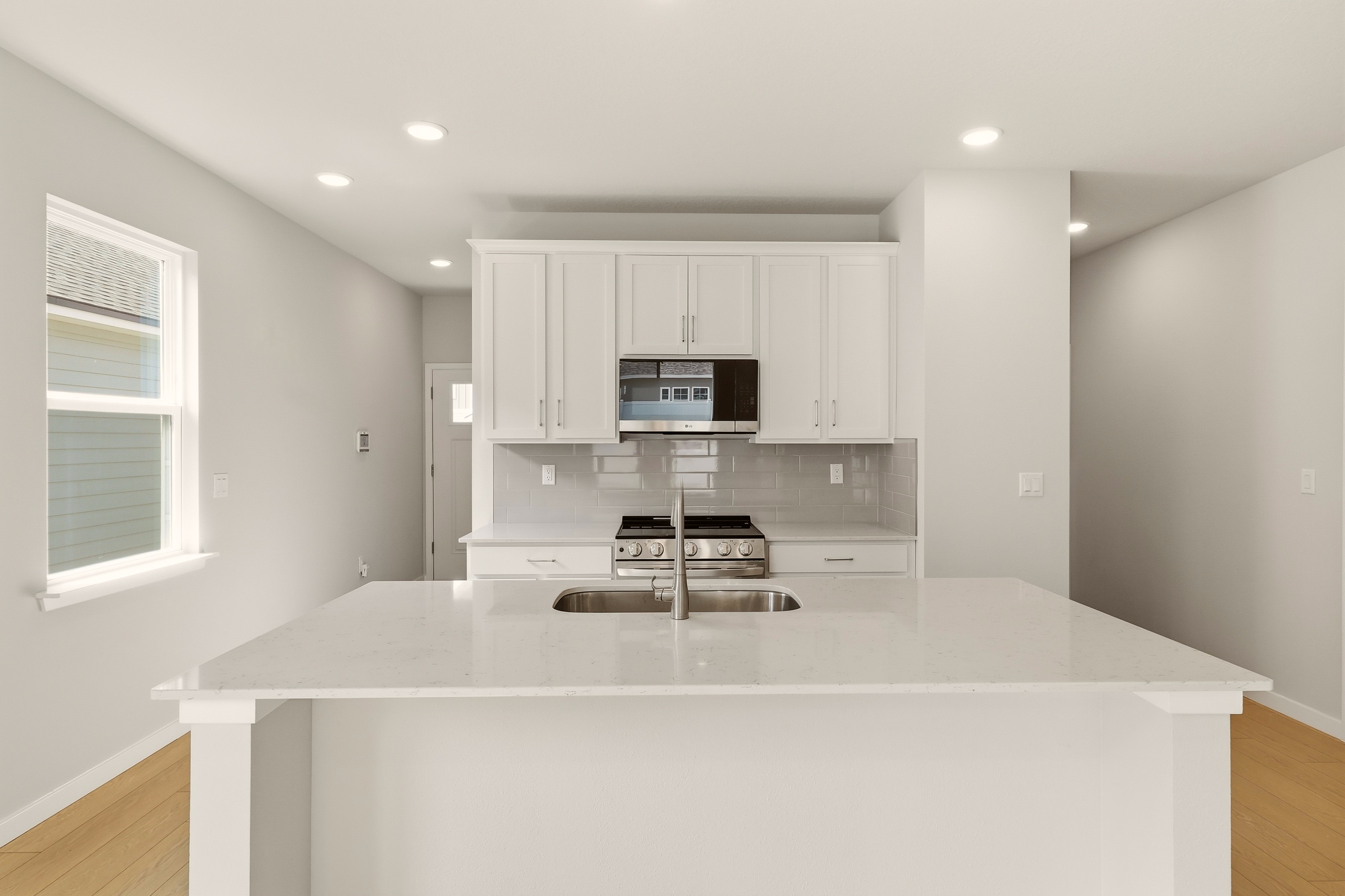 A kitchen with white cabinets.