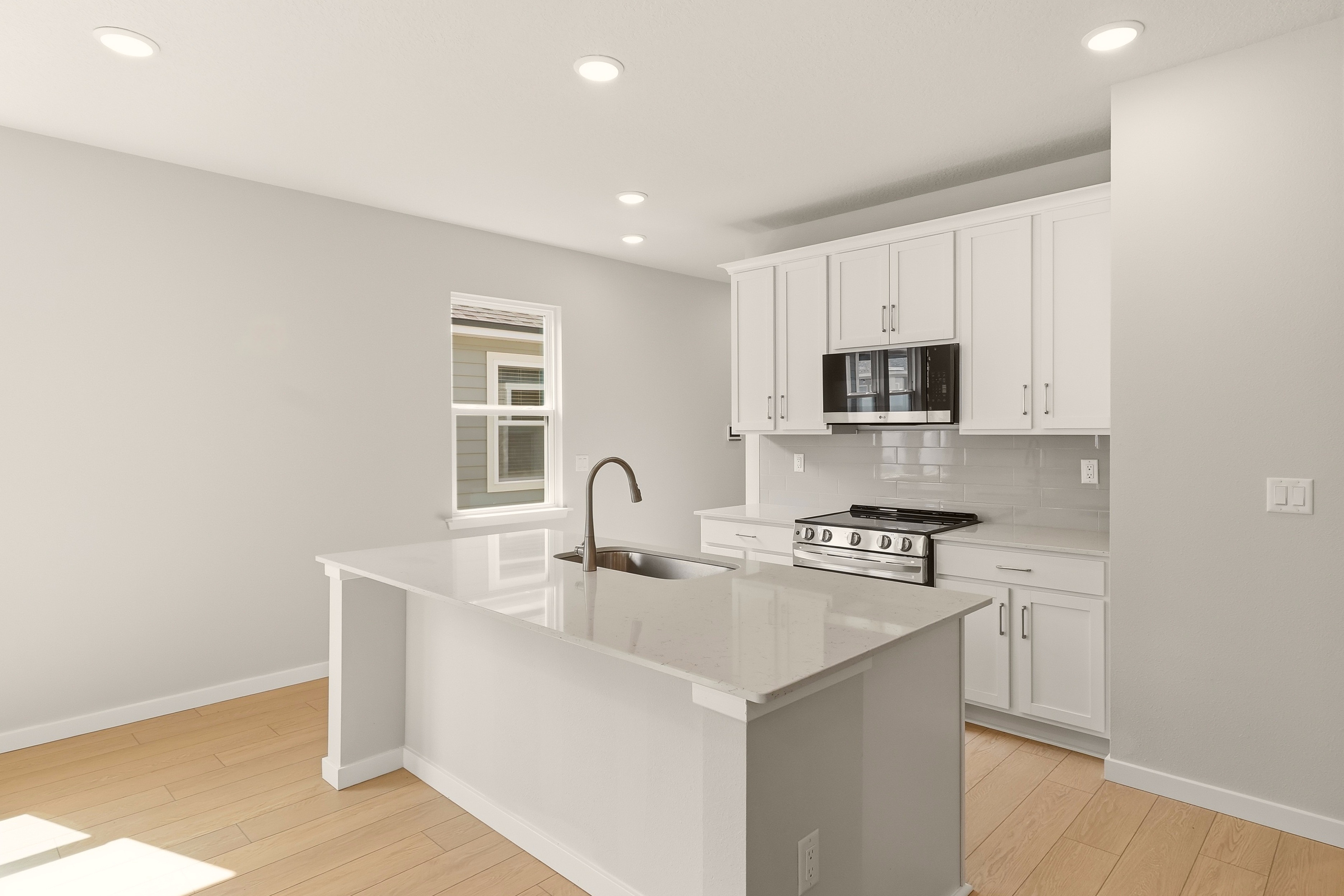 A kitchen with white cabinets.