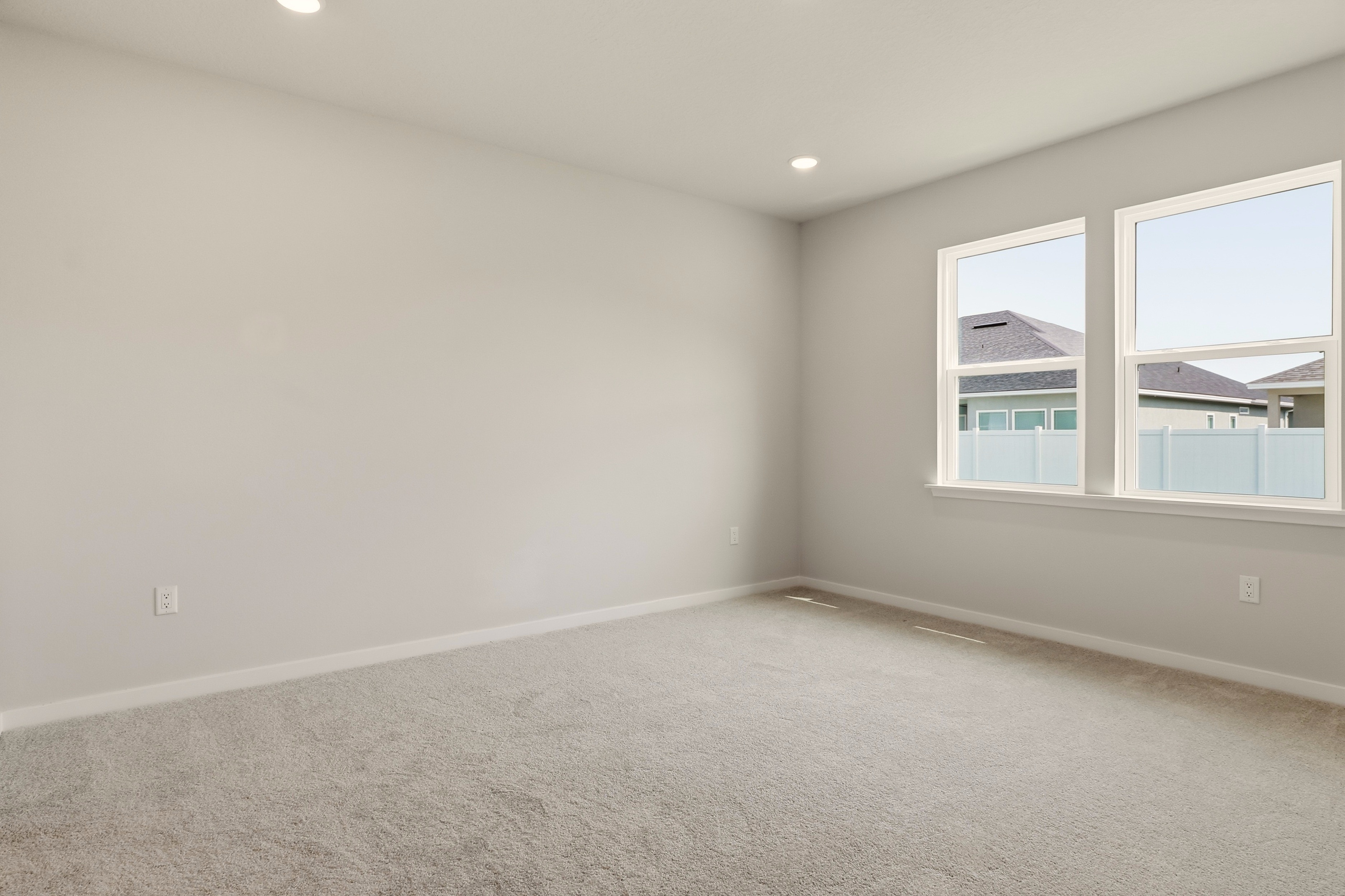A room with a window and a white wall.