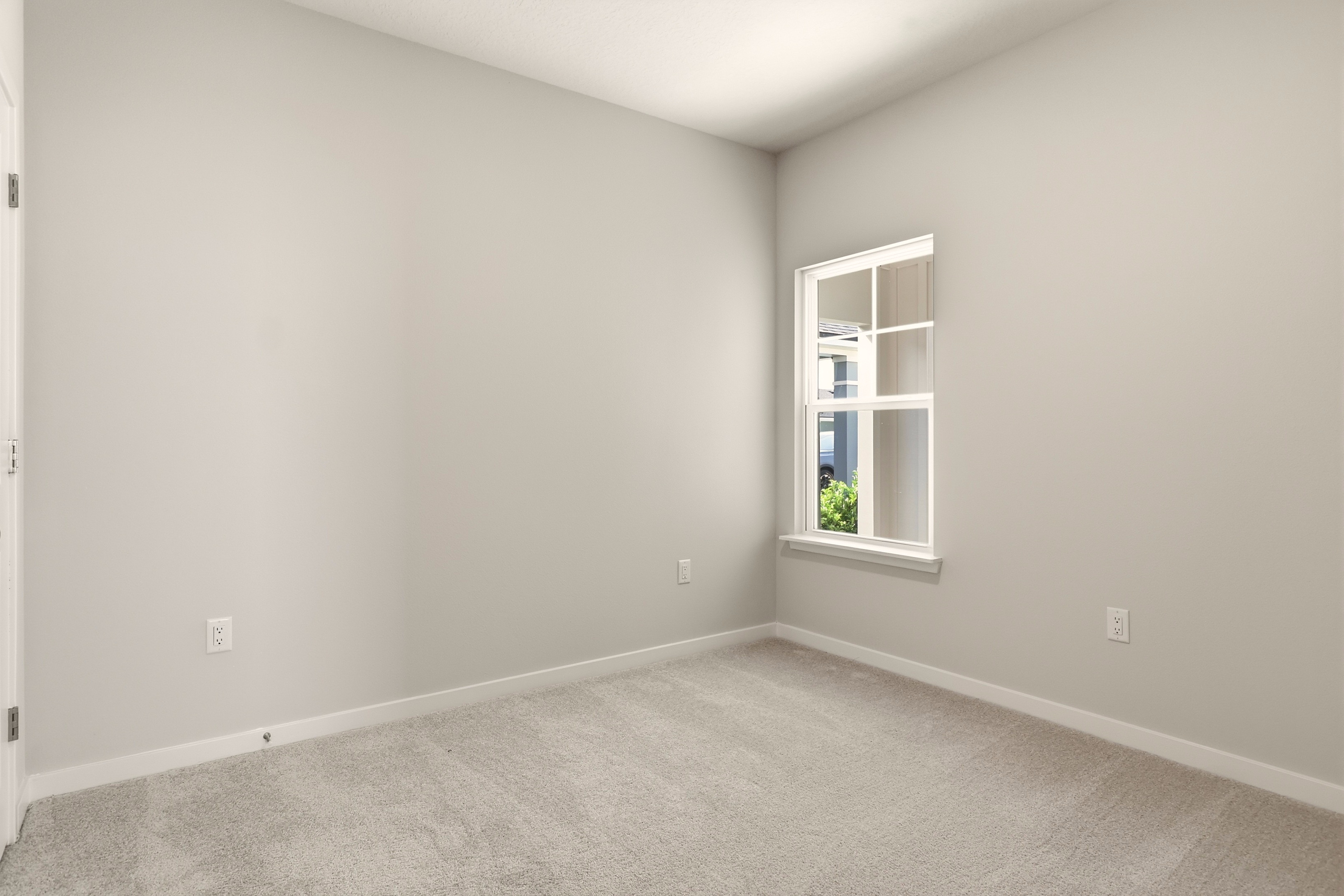 A room with a window and carpet.