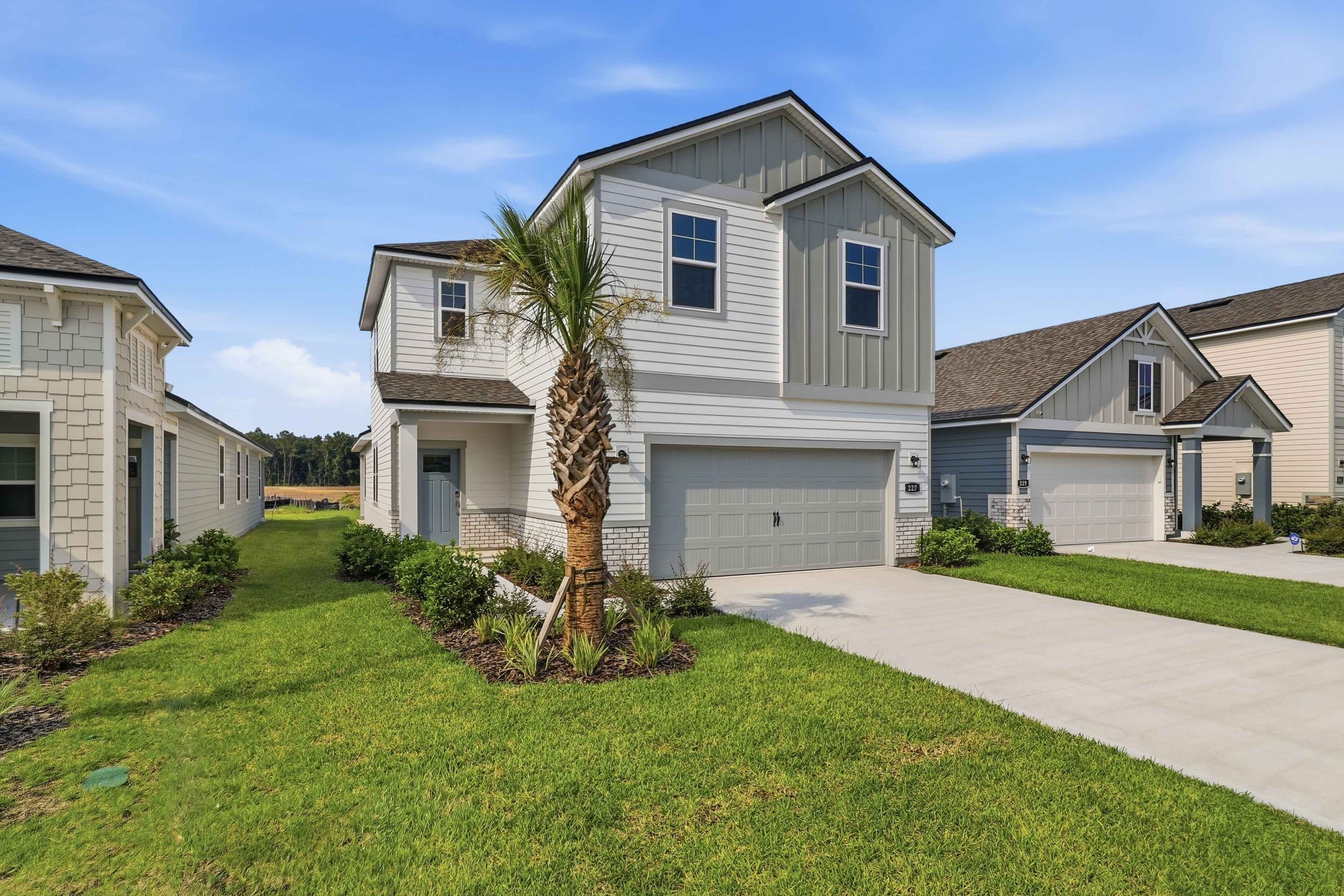 A house with a tree in the front yard.