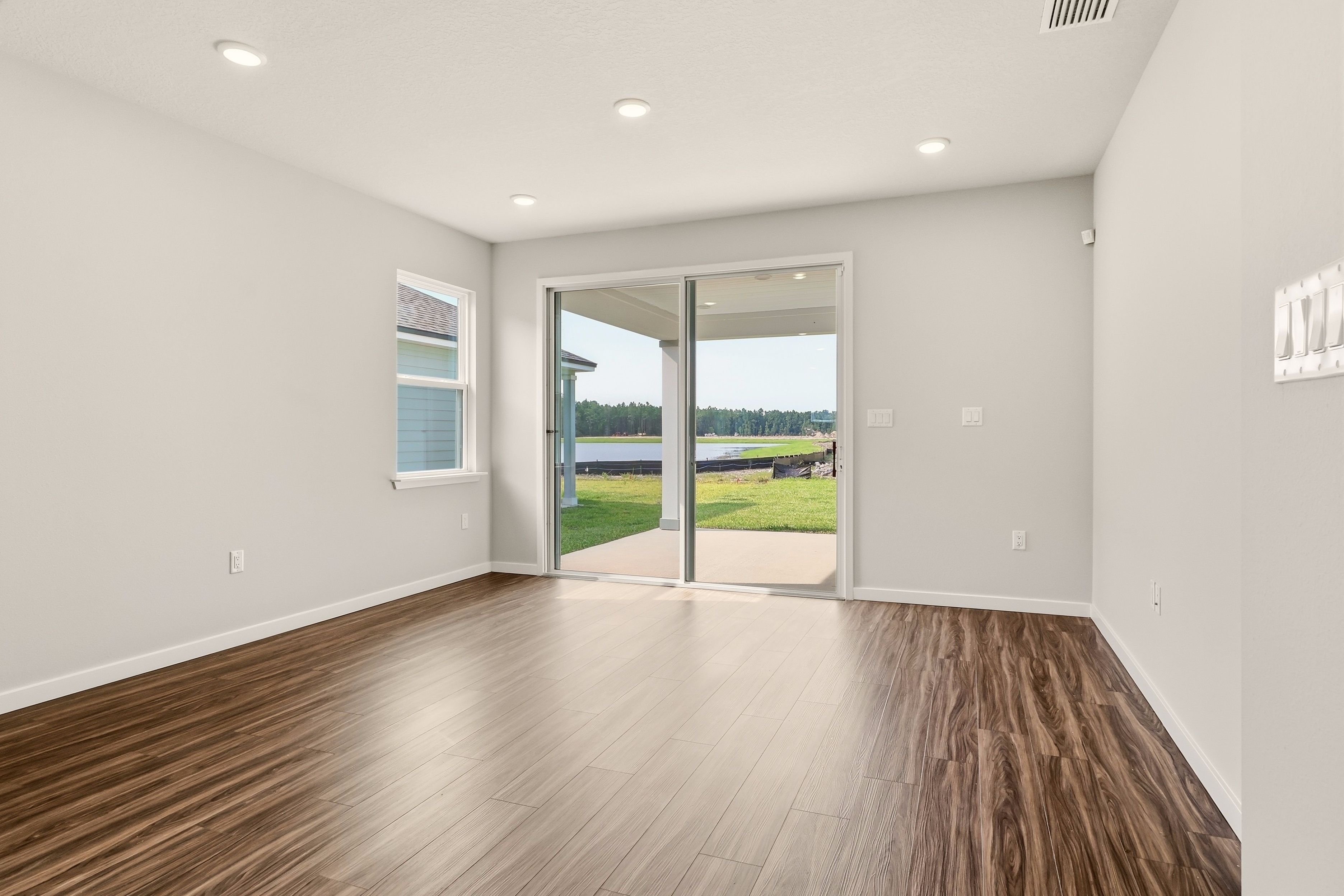 A room with a wood floor and a wood floor with a large window.