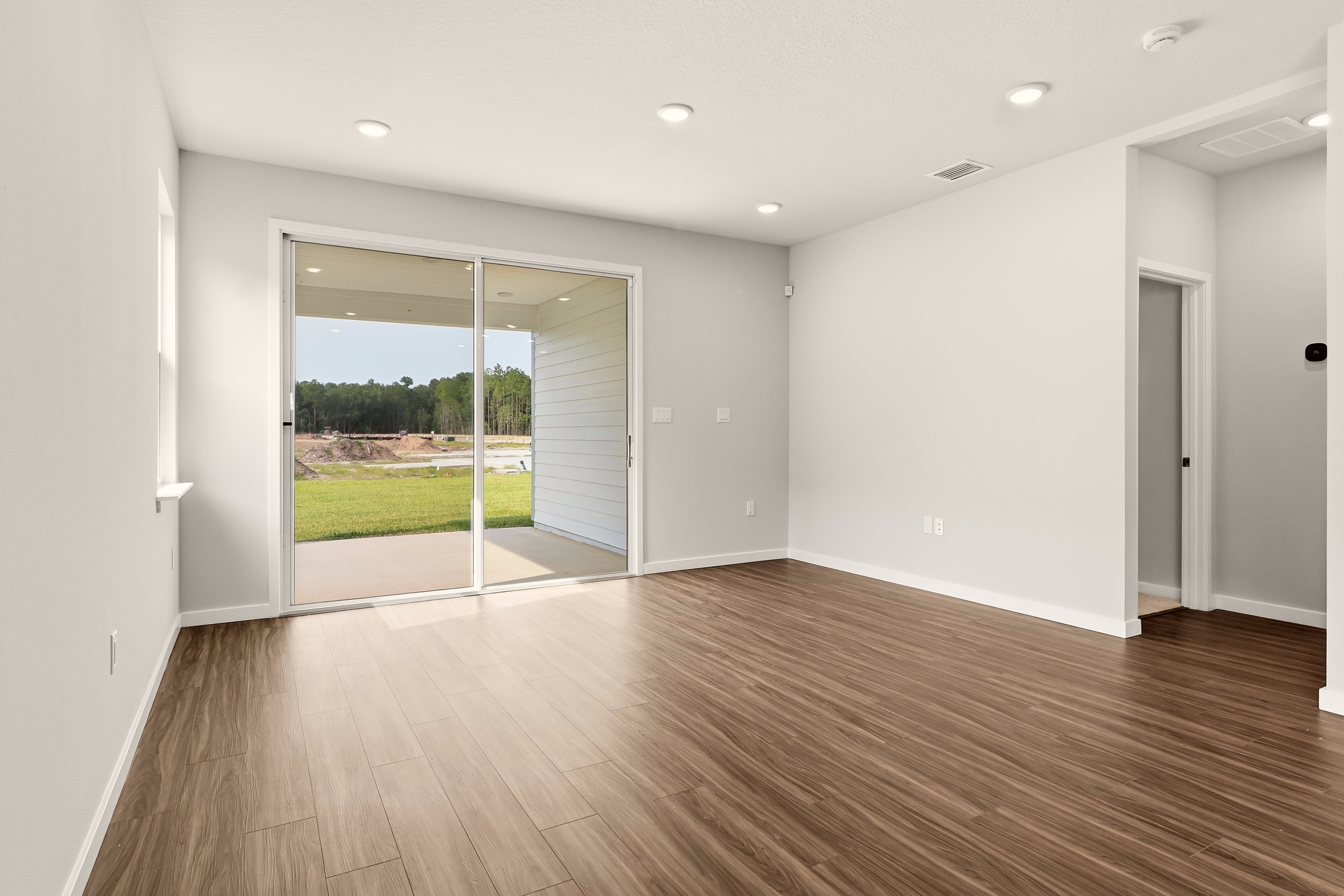 A room with a wood floor and a glass door.