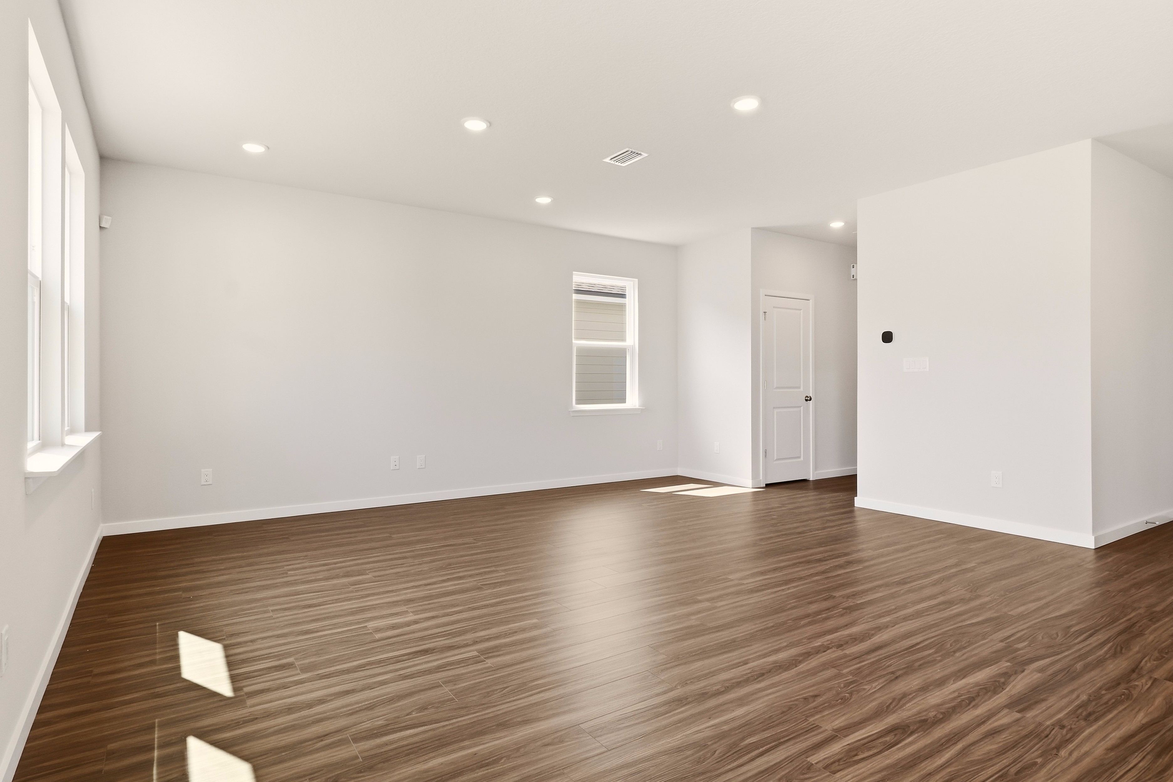 A room with a wood floor and white walls.