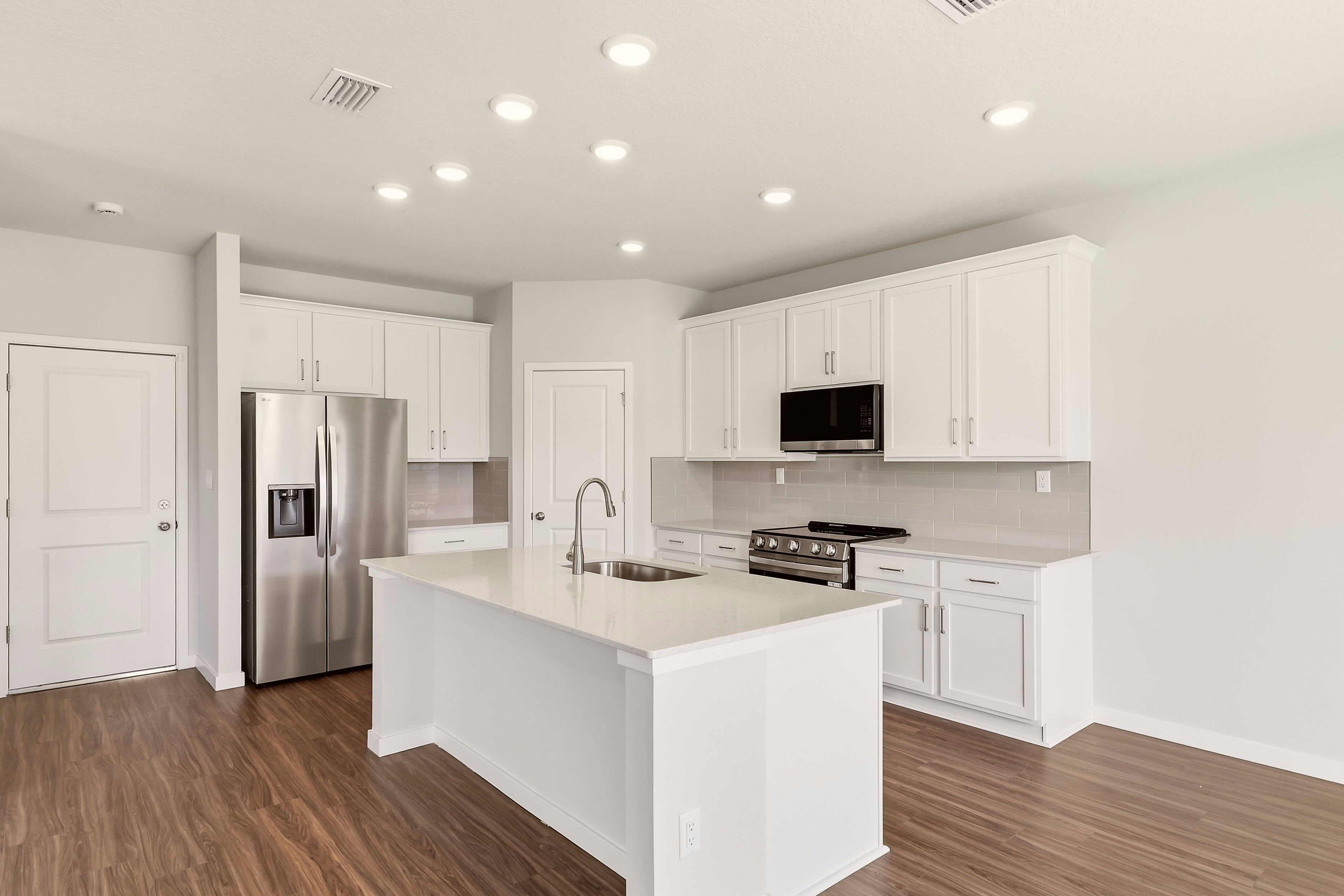 A kitchen with white cabinets.