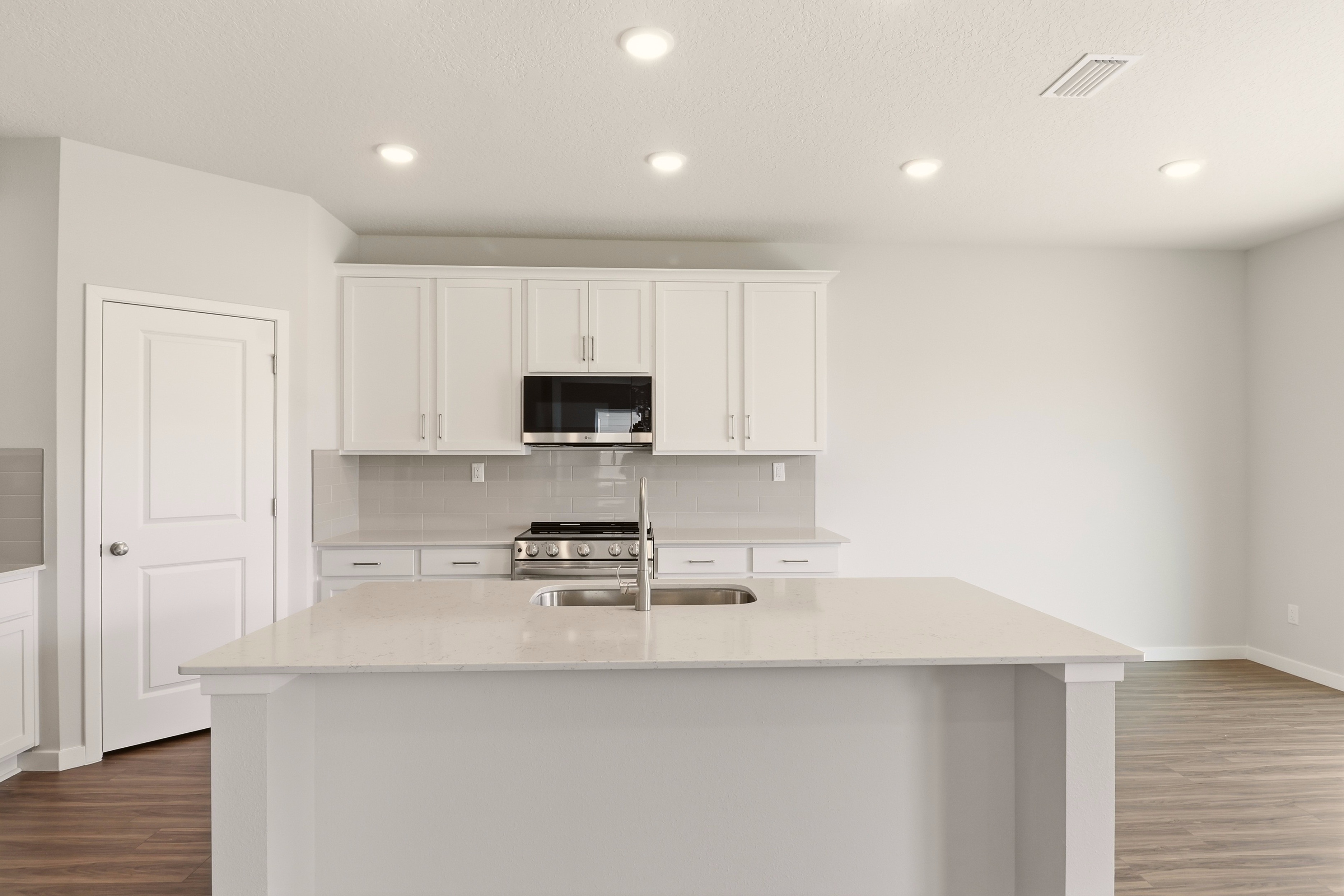 A kitchen with white cabinets.