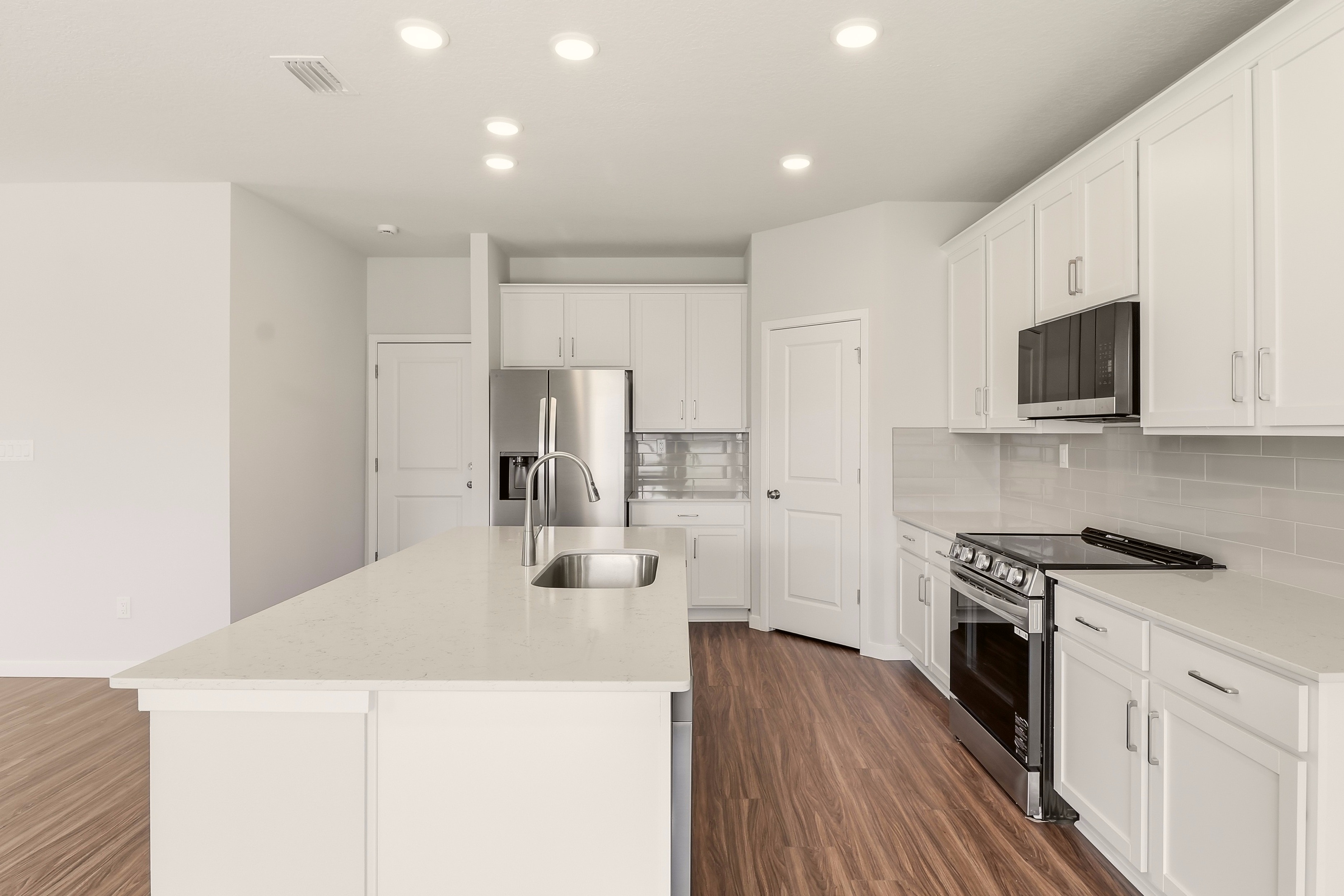 A kitchen with white cabinets.