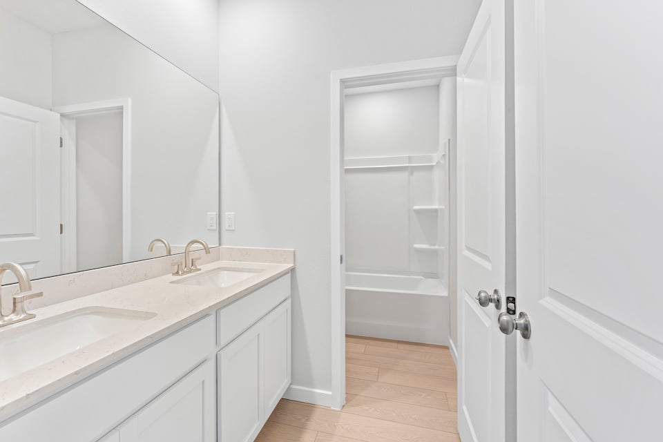 Lot 20 Ponderosa II Guest Bathroom with Double Vanity Sink and Tub Shower Combo at Camden Woods in Kingsland, GA