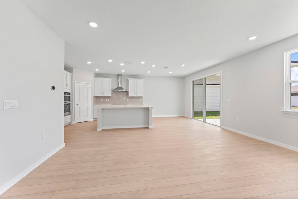Lot 20 Ponderosa II Living Area Looking at Kitchen and Sliding Patio Doors at Camden Woods in Kingsland, GA