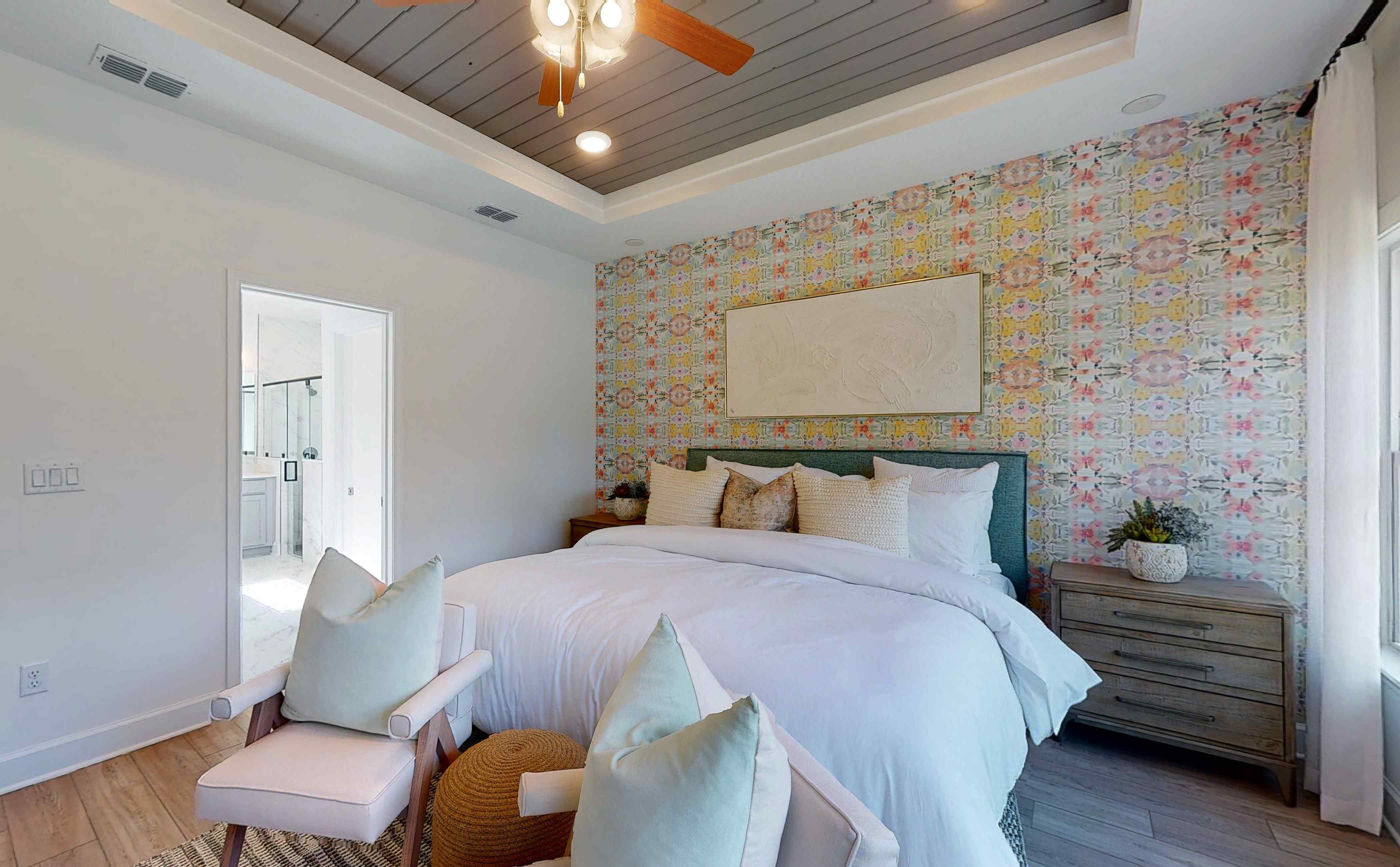 A bedroom with a bed and a chair.