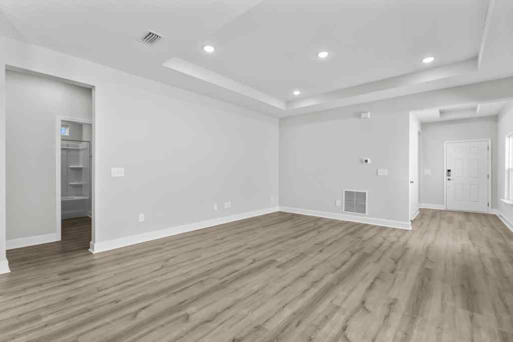 A room with white walls and wood floors.