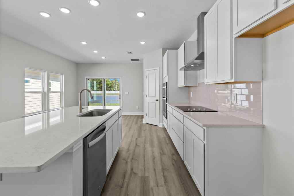 A kitchen with white cabinets.