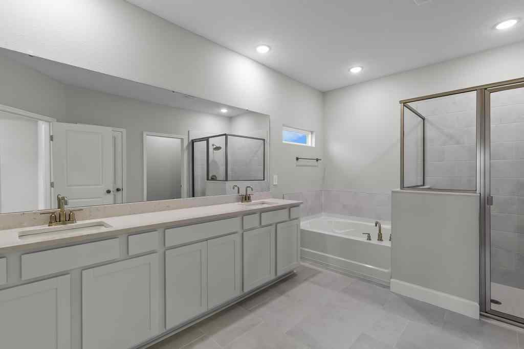 A bathroom with a tub sink and shower.