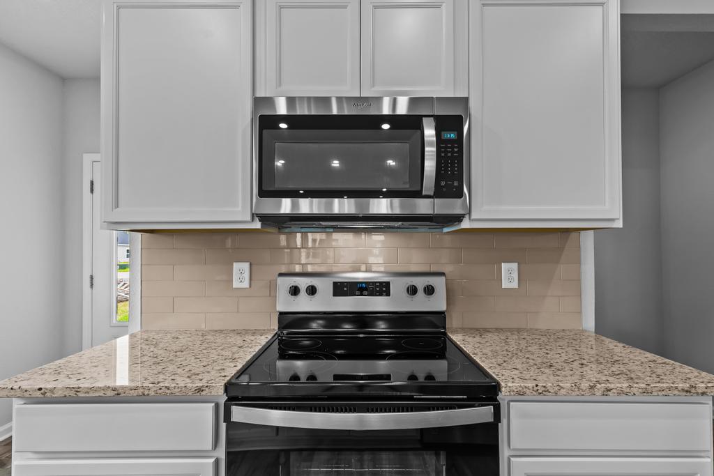 A kitchen with white cabinets.