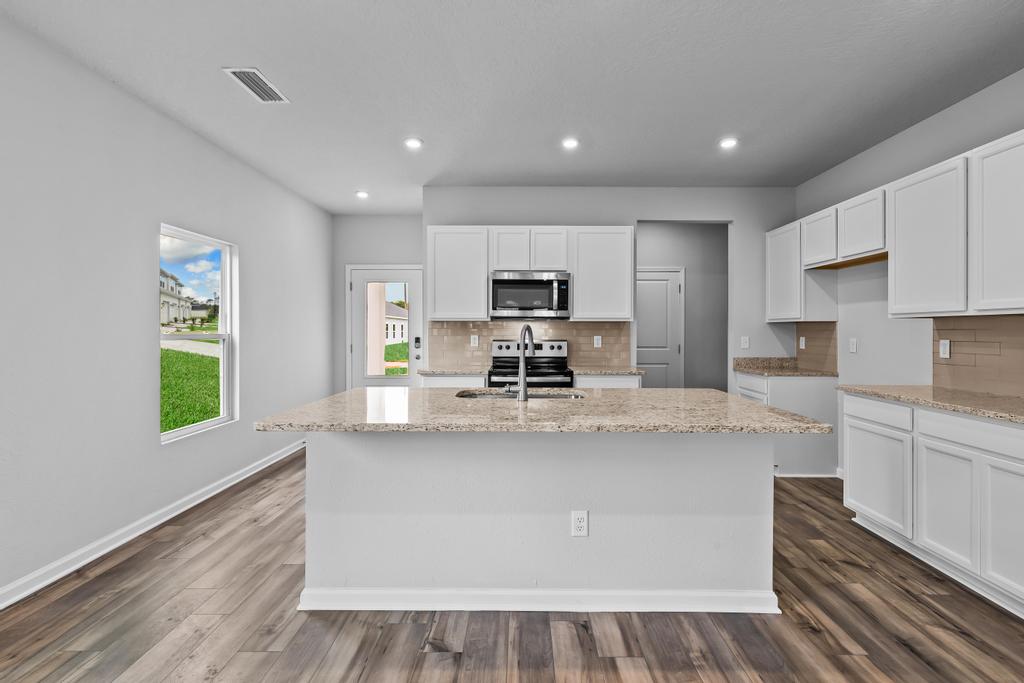 A kitchen with white cabinets.