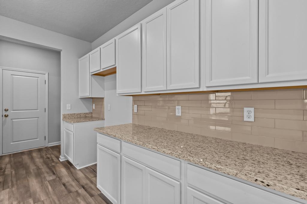 A kitchen with white cabinets.