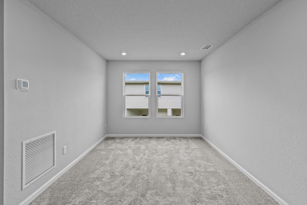 A room with a window and a carpet.