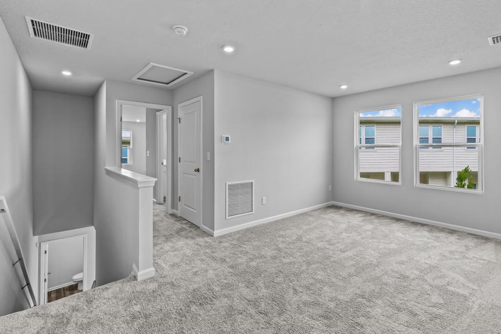 A room with a carpet and windows.