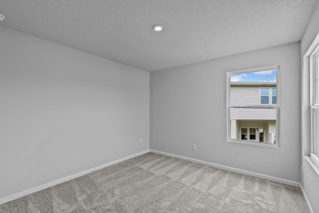 A room with a window and a carpet.