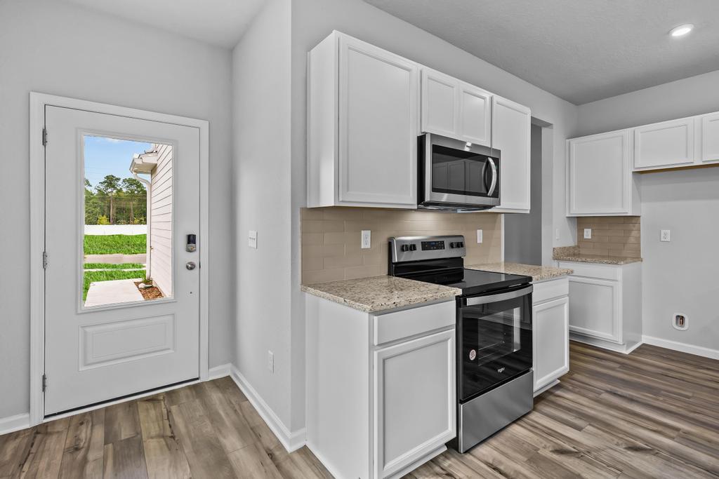 A kitchen with white cabinets.