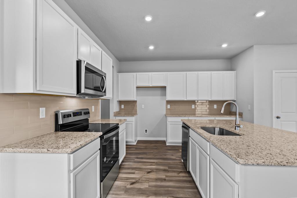 A kitchen with white cabinets.