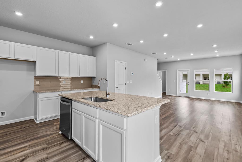 A kitchen with white cabinets.