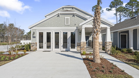 A white house with a tree in front of it.