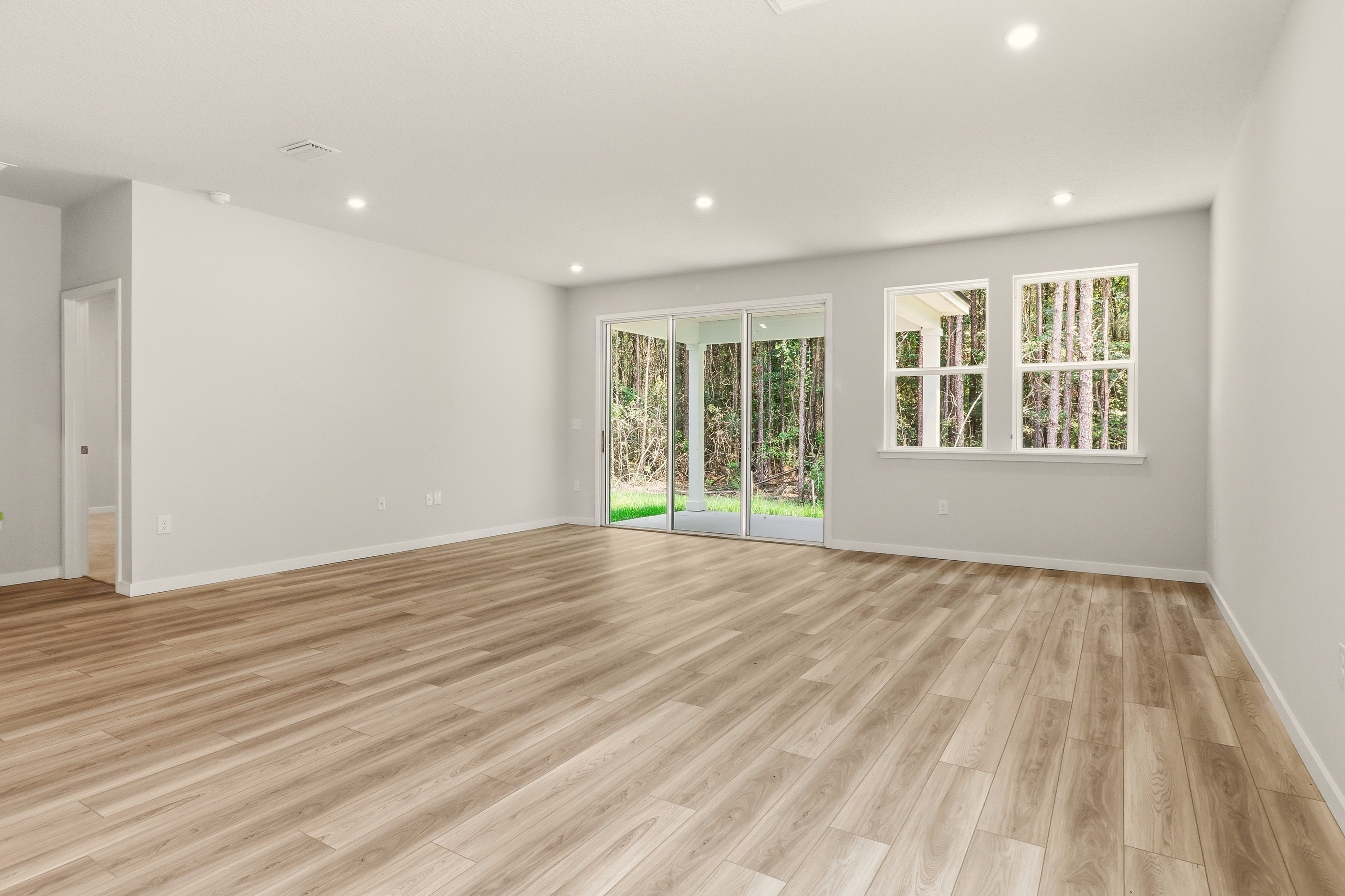 A room with a wood floor and windows.