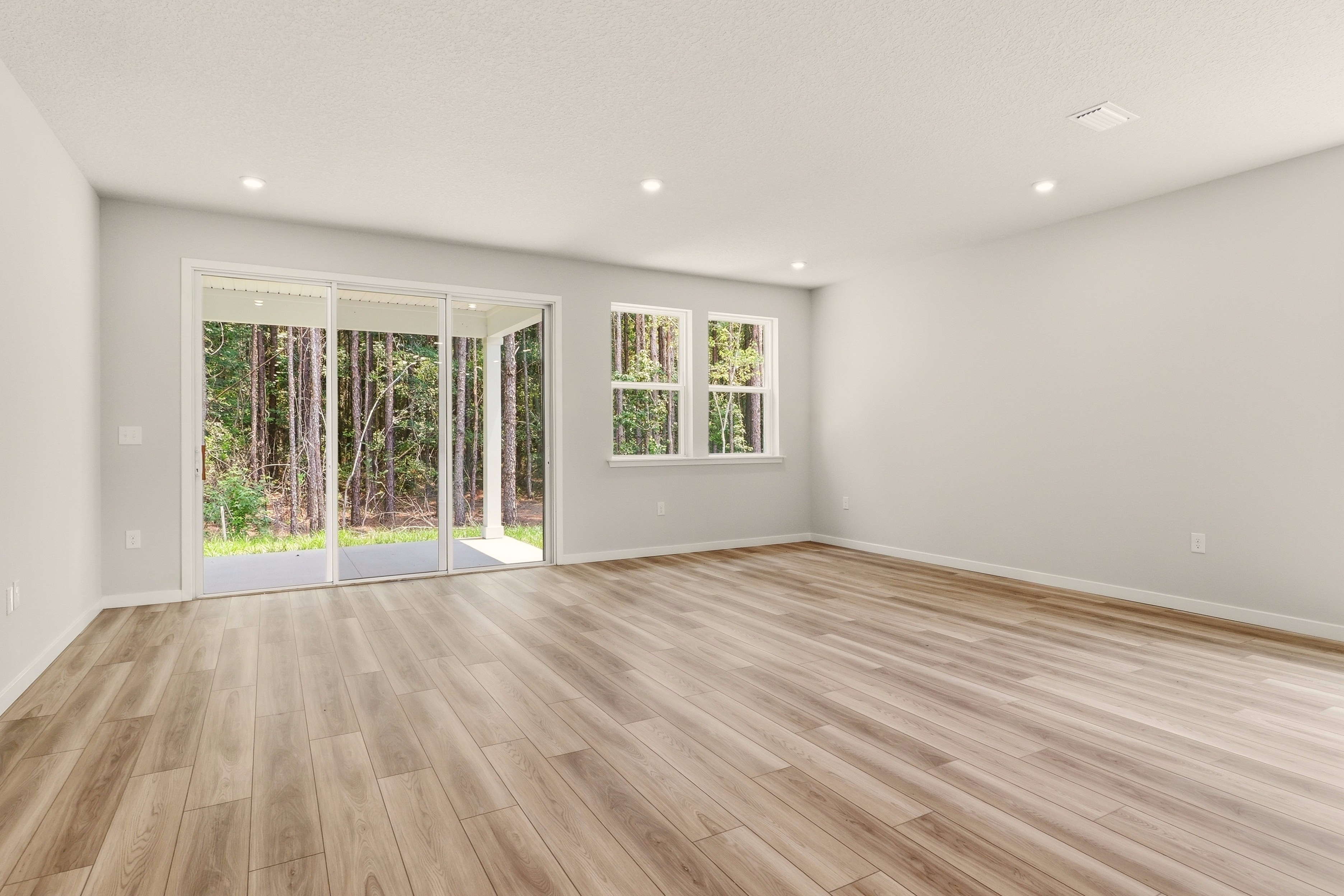A room with a wood floor and windows.