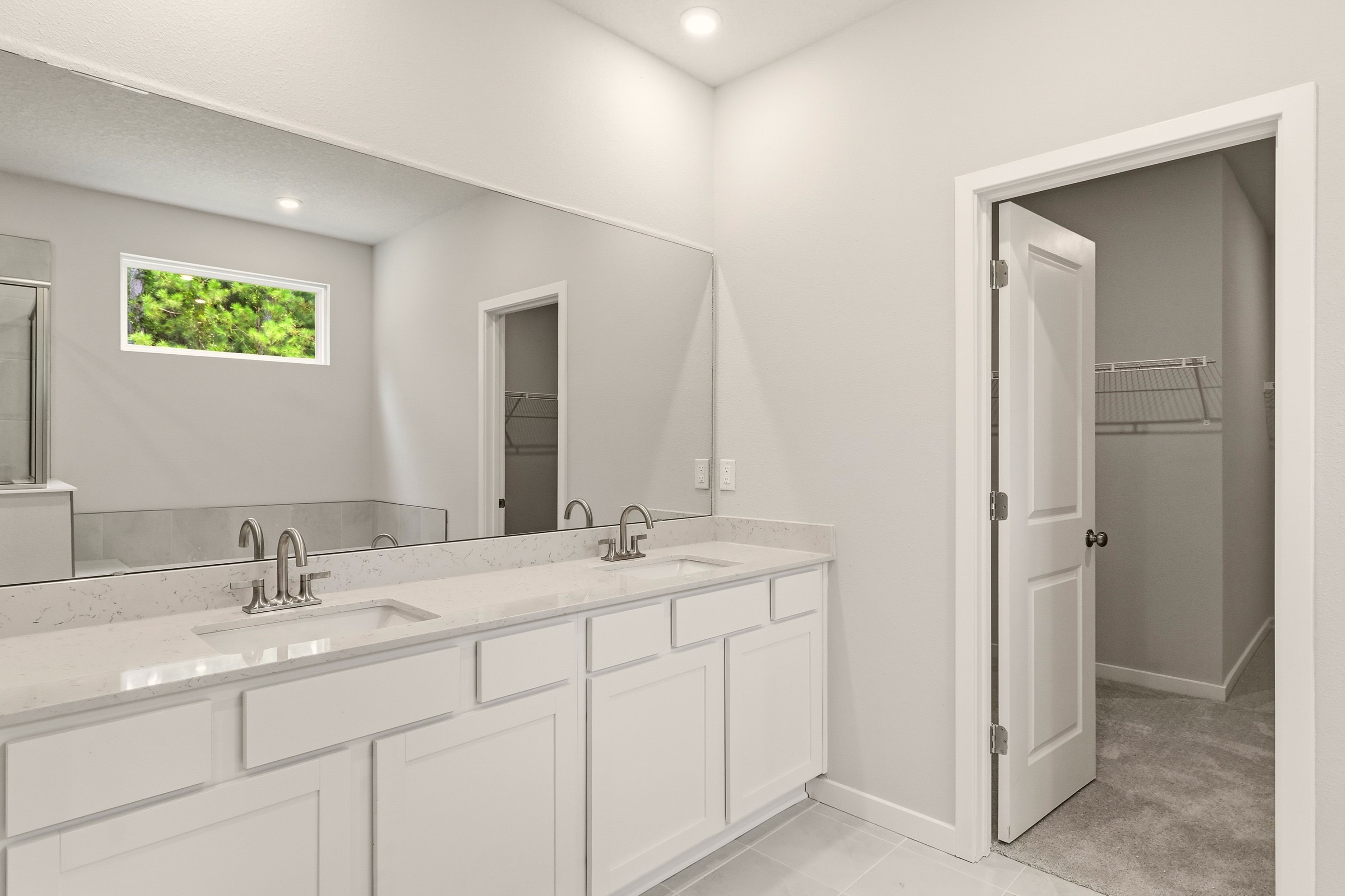 A bathroom with white cabinets.
