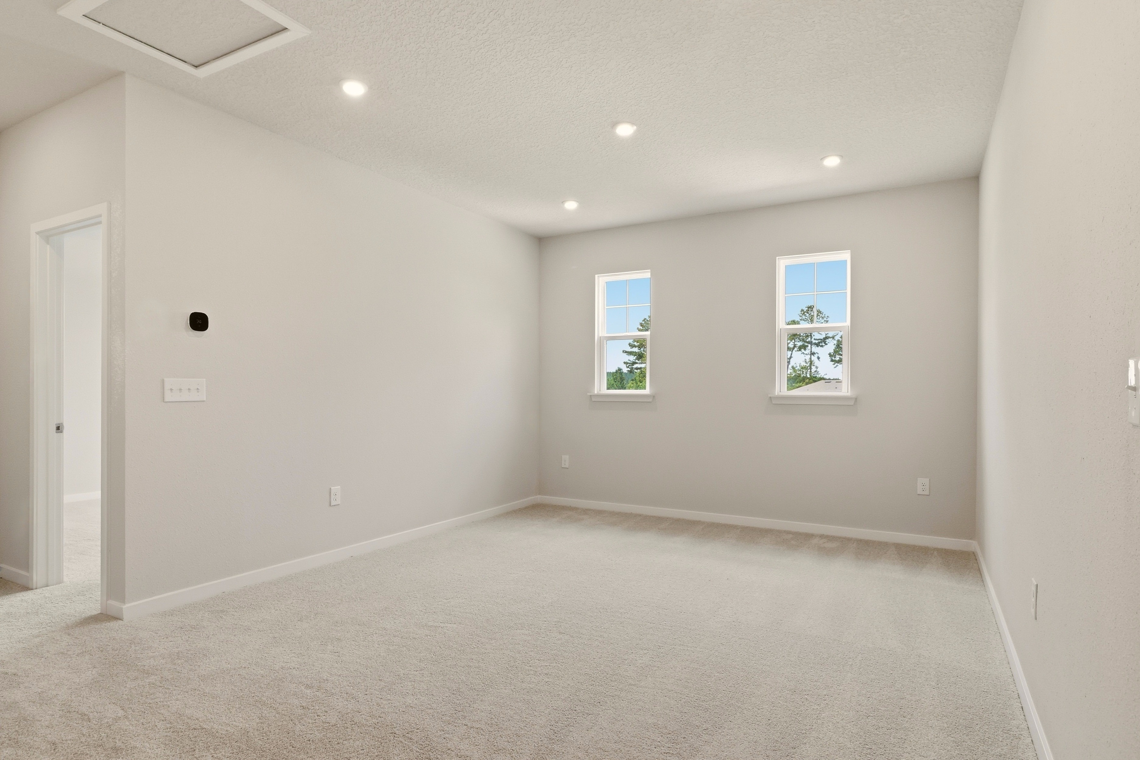 A room with a carpet and windows.