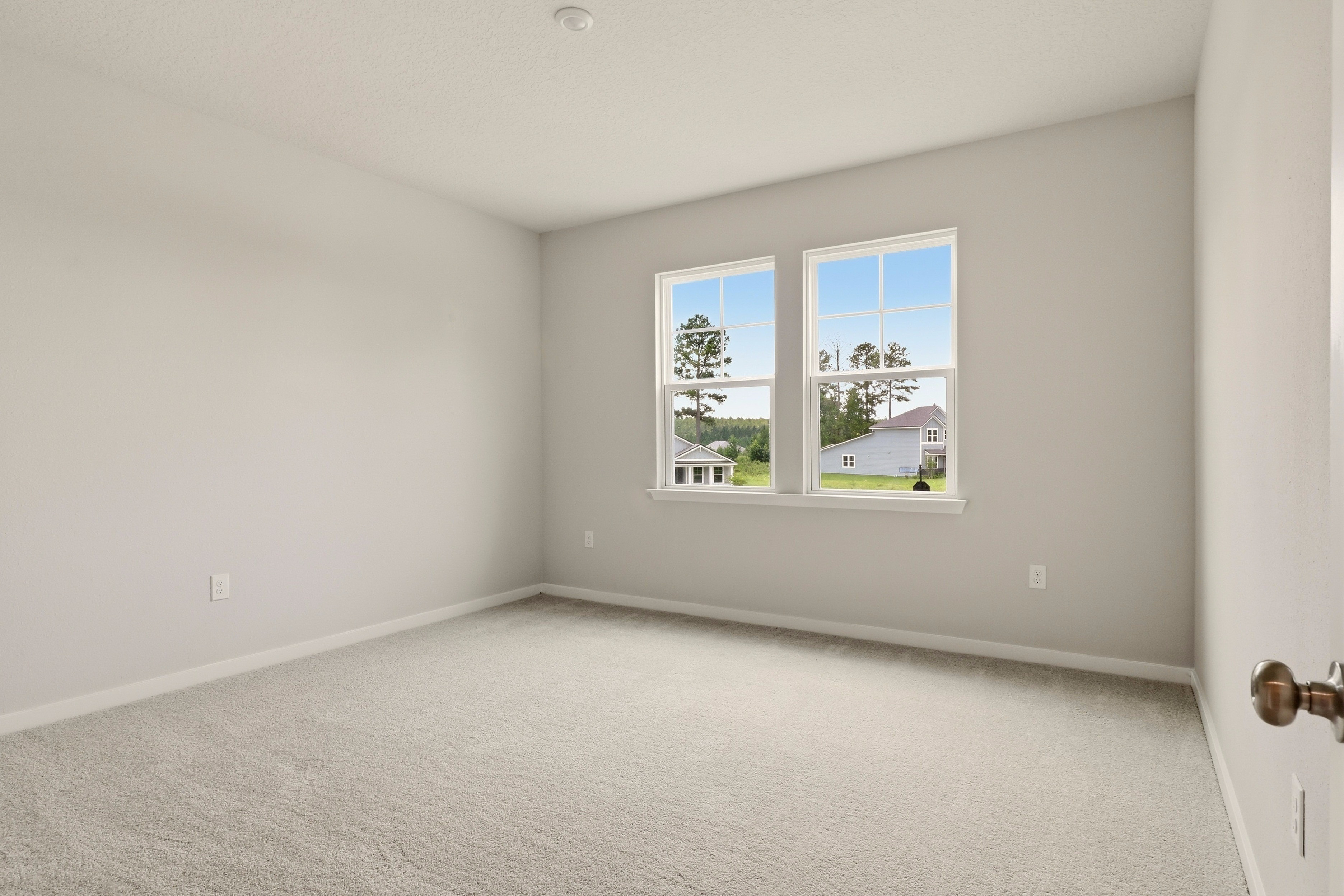 A room with a window and a carpet.