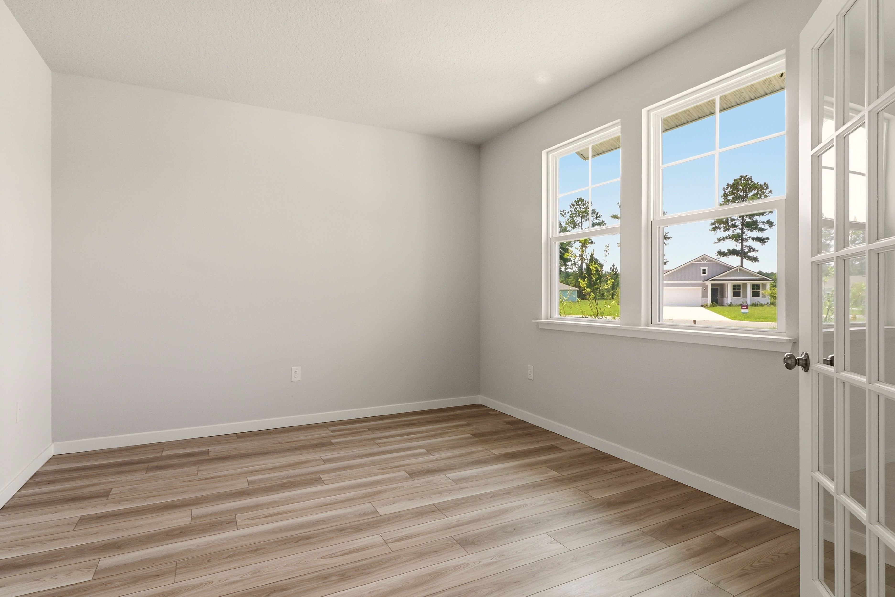 A room with a wood floor and windows.