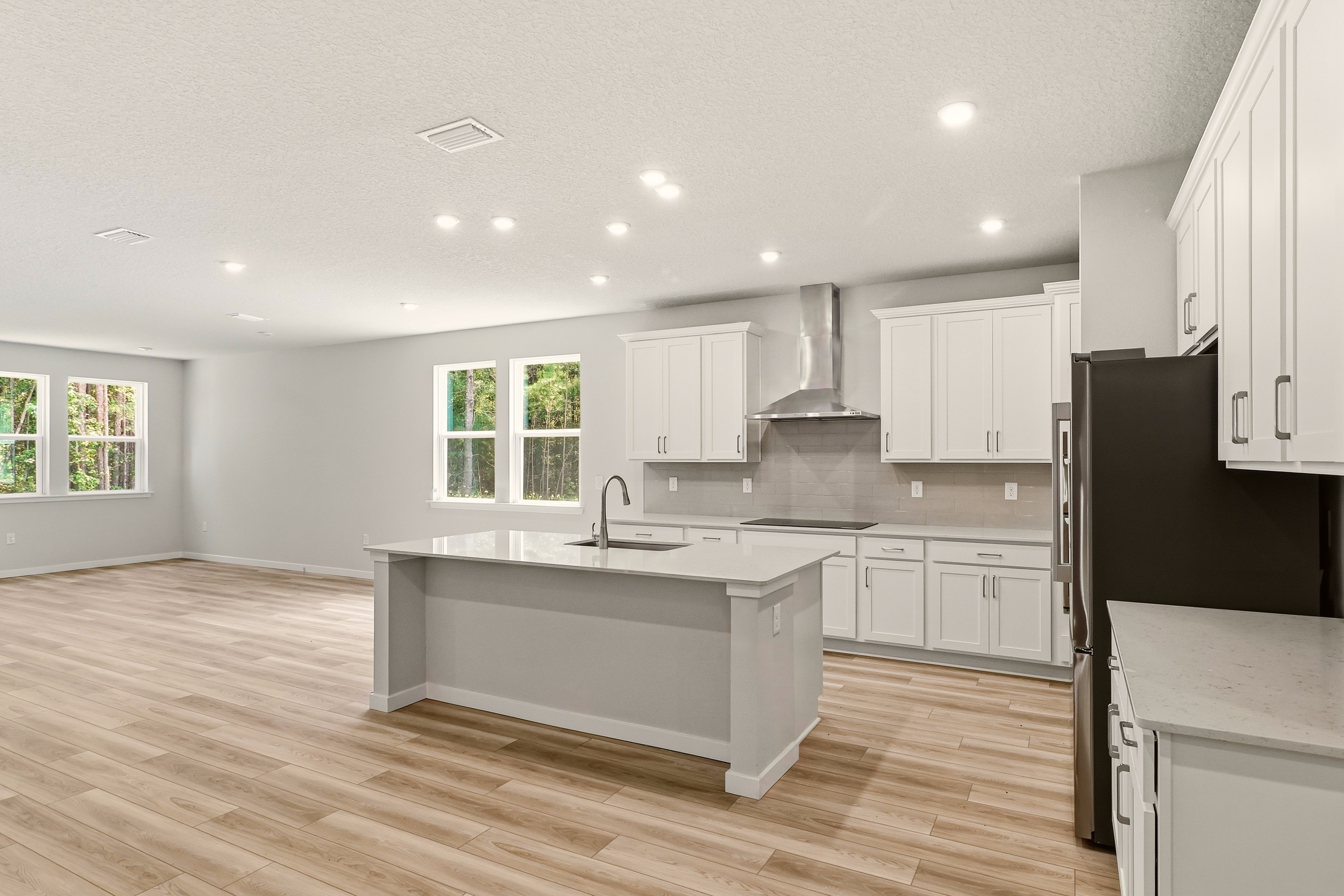 A kitchen with white cabinets.